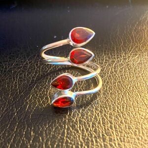 A deep rich red garnet bypass ring. Can flex from a size 5.5 to 8+.